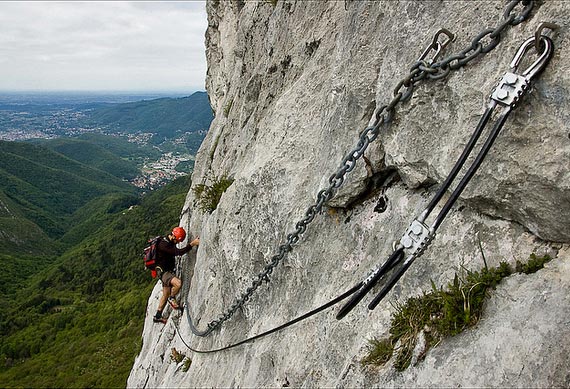 Escursionista alle prese con il lungo e aereo traverso della ferrata del Venticinquennale al Corno di Canzo Occidentale