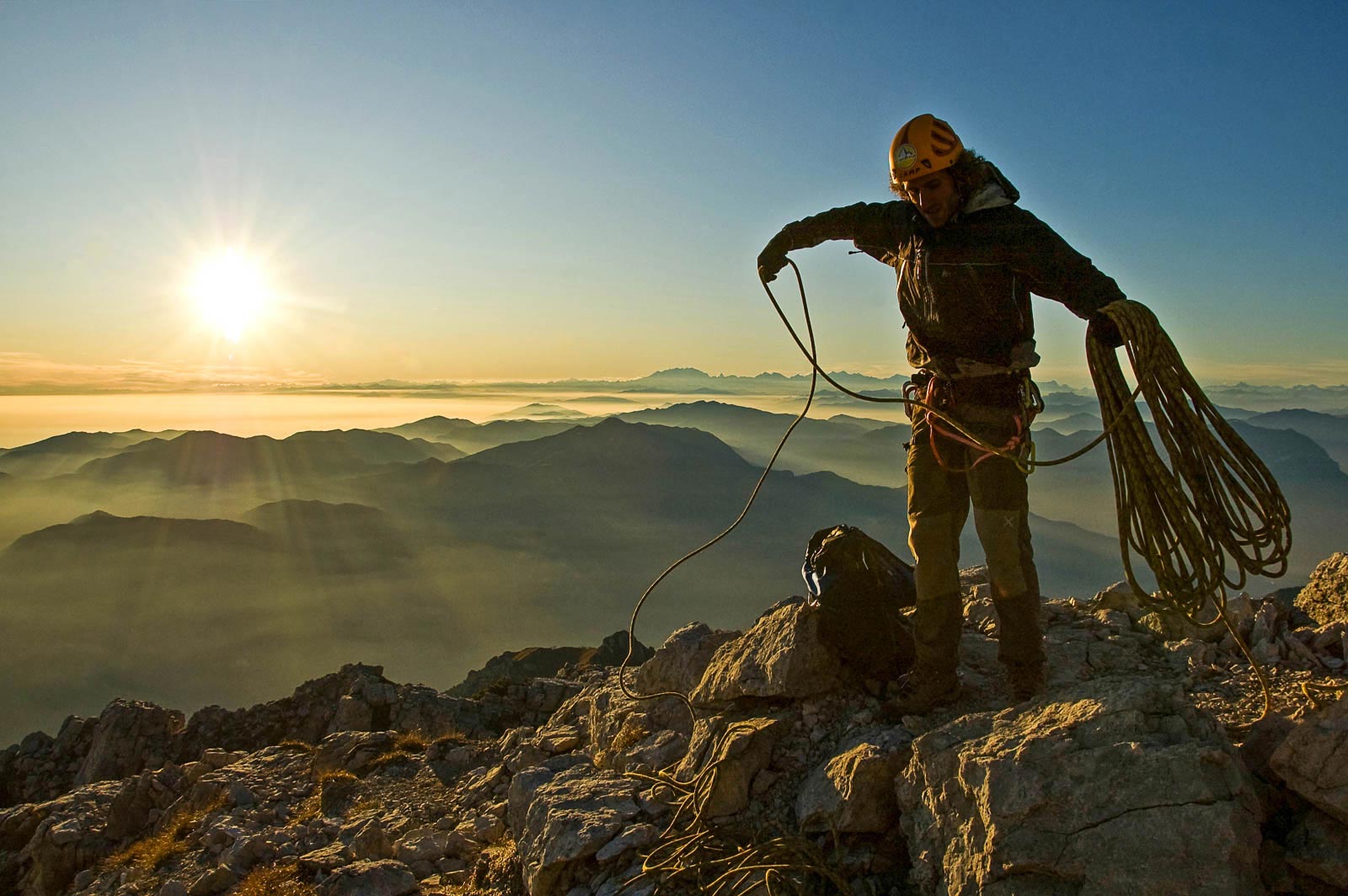 Un alpinista riordina la corda al termine della risalita della cresta Segantini, Grigna Meridionale.