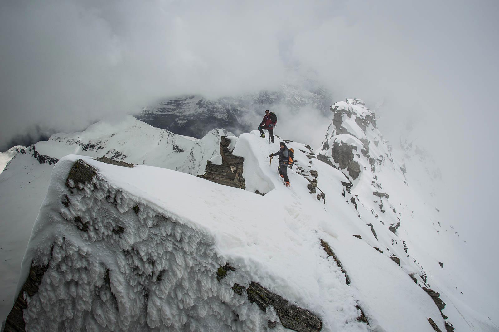 Due alpinisti risalgono la cresta sud del monte Leone, classica scialpinistica primaverile al passo del Sempione.