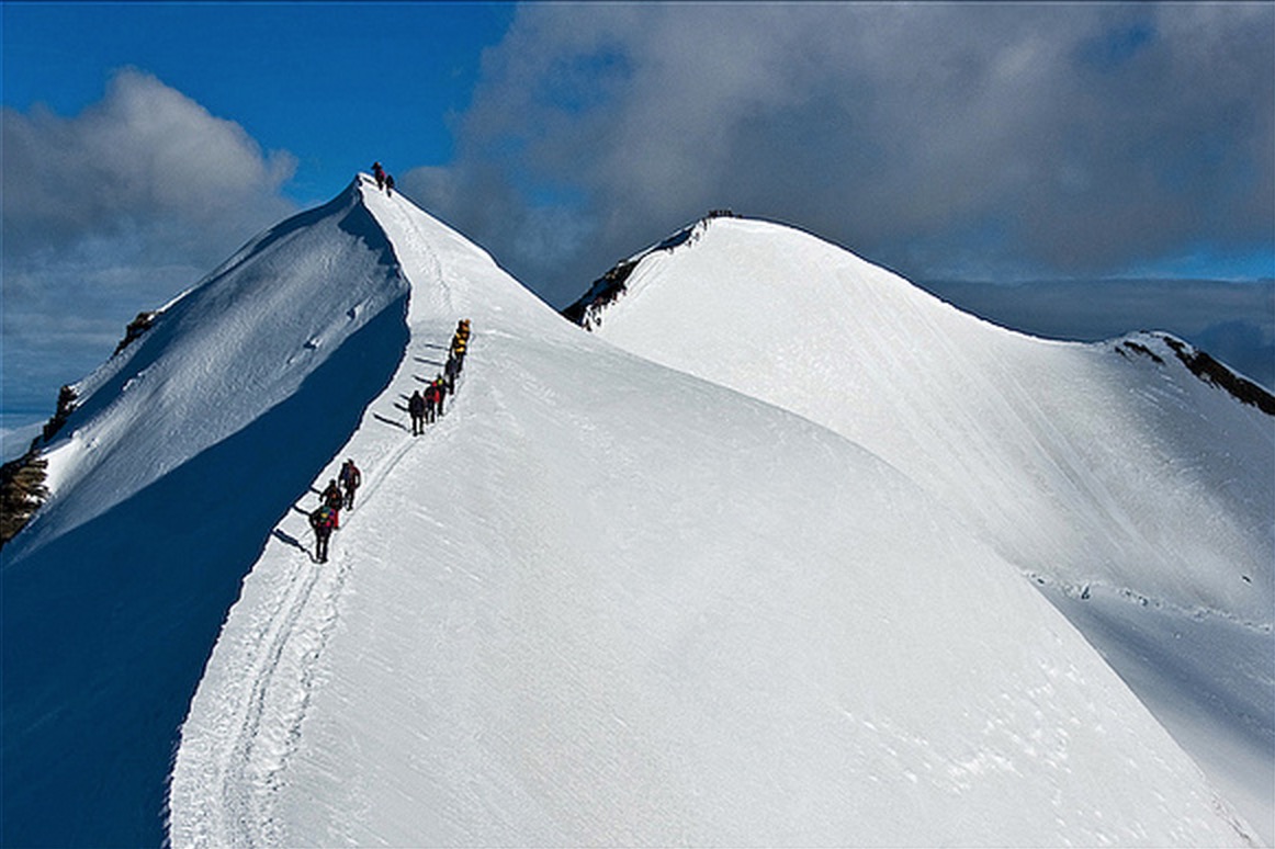 Cordate di alpinisti risalgono la ``schiena di mulo`` sulla via normale al Gran Paradiso, 4061 m.